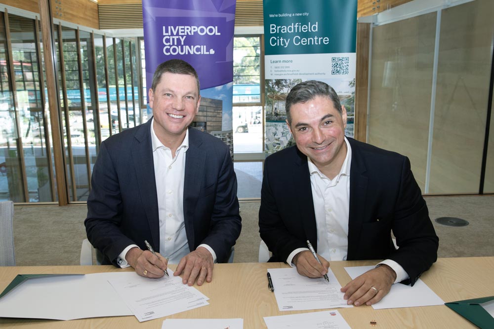 Two business men signing paperwork