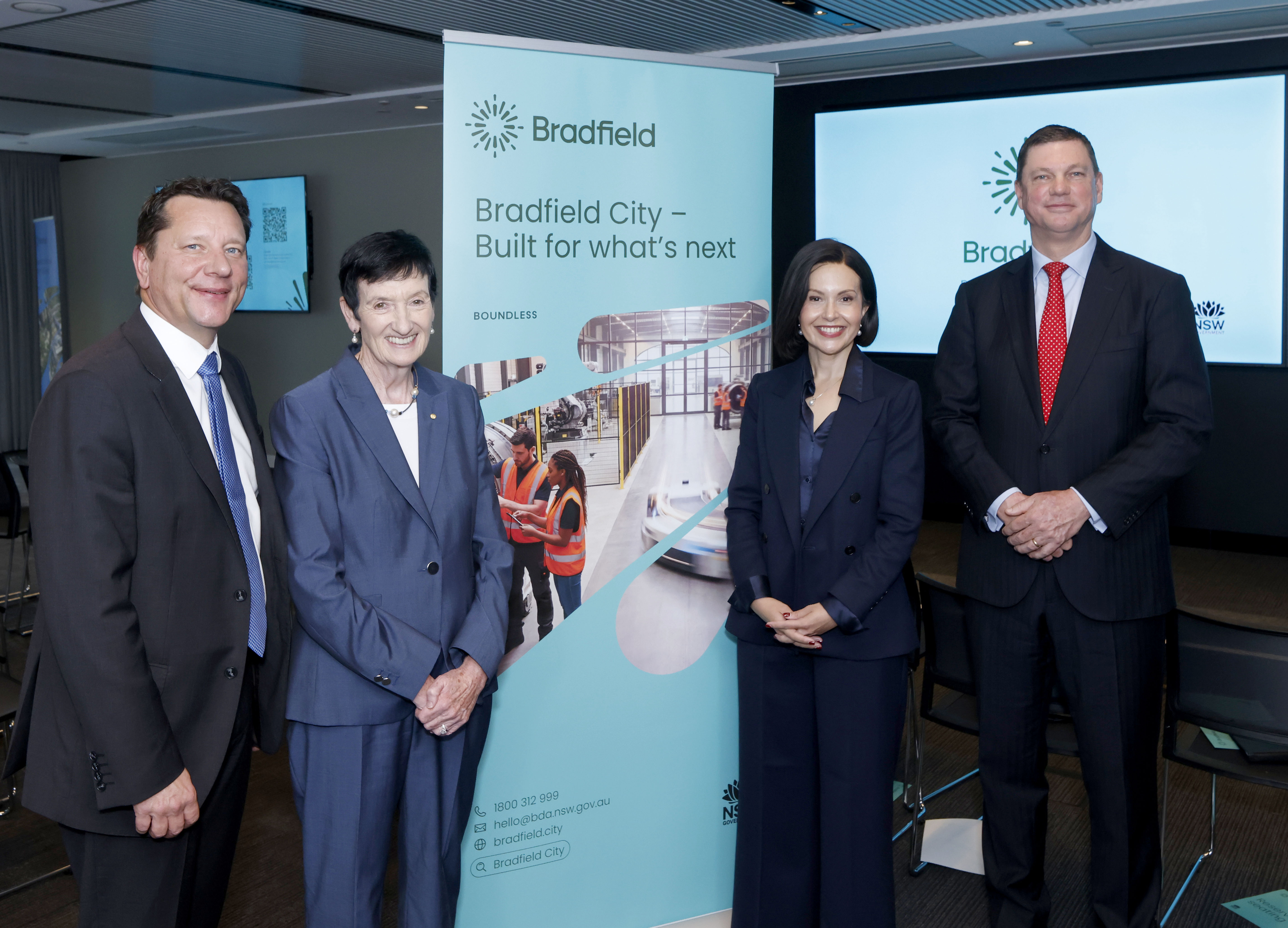 Four people stand on either side of a banner saying Bradfield City - Built for what's next