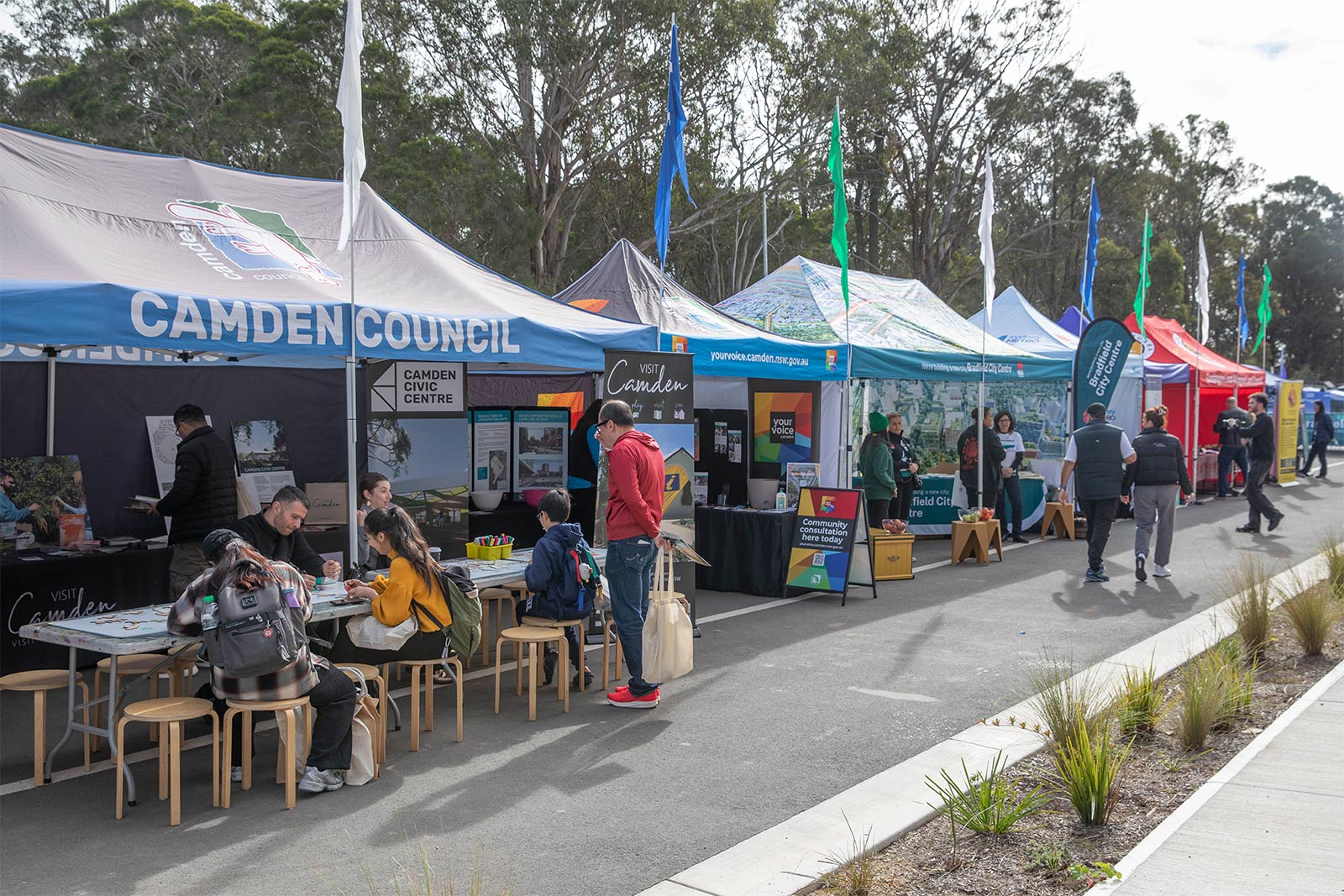People visiting outdoor market stalls at a community event