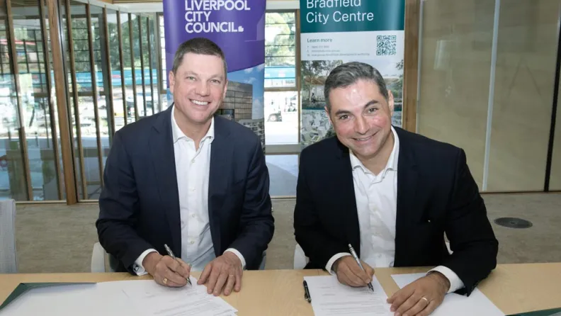 Two business men signing paperwork