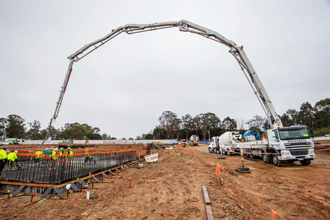 A truck and workers pouring a concrete slab
