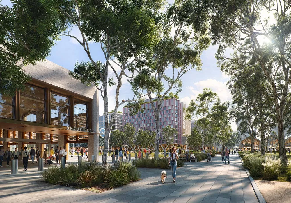 A metro station opposite mixed-use city buildings surrounded by trees and greenspace