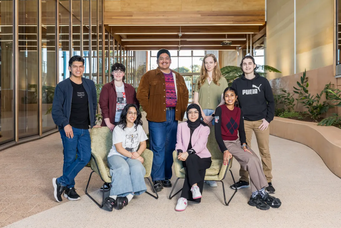 Group of eight students in the atrium of the First Building at Bradfield City